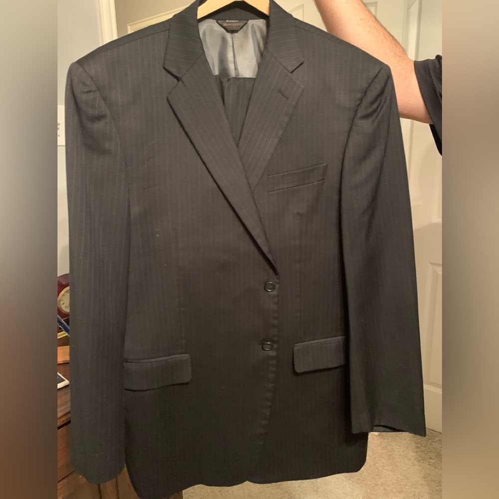 Pinstriped charcoal suit. Pants w/pleats and cuffs. Subtle blue & tan stripes.